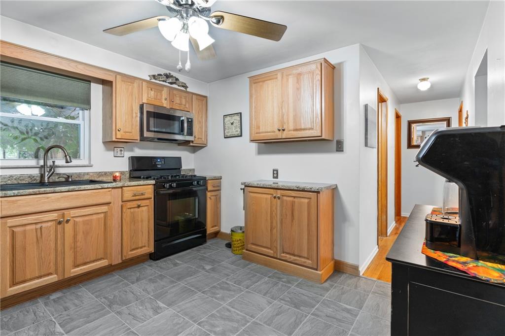 412 Holyoke Road Butler, PA 16001 - Photo 6 of 29 a kitchen with stainless steel appliances granite countertop a refrigerator oven a sink dishwasher and white cabinets with wooden floor