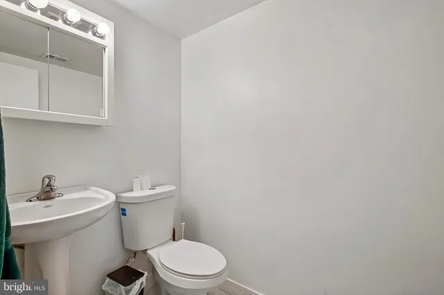 a white toilet sitting next to a bathroom sink