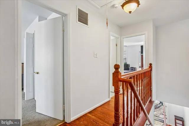 a view of a hallway with wooden floor and entryway
