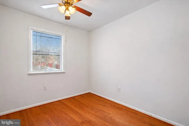 an empty room with a window and a ceiling fan