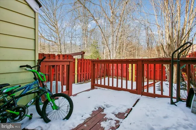 a view of a backyard with a large tree and wooden deck