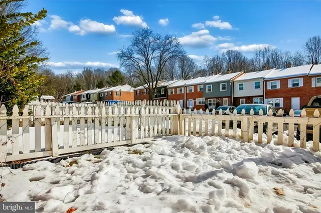 a view of a house with a wooden fence