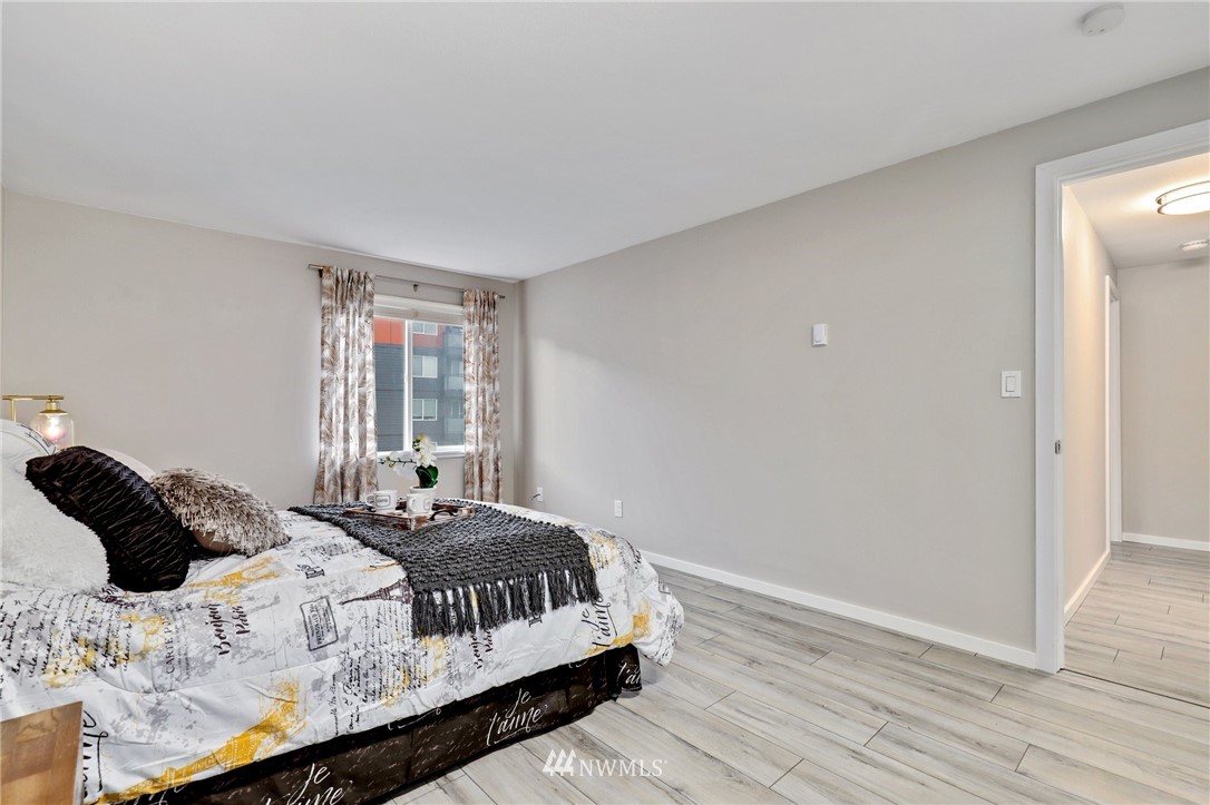 7001 Sand Point Way Northeast, Unit C309 Seattle, WA 98115 - Photo 12 of 38 a bedroom with a bed and wooden floor