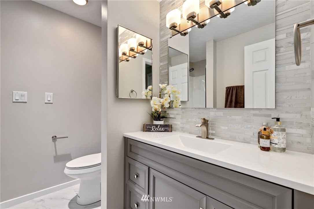 7001 Sand Point Way Northeast, Unit C309 Seattle, WA 98115 - Photo 17 of 38 a bathroom with a toilet a sink and mirror