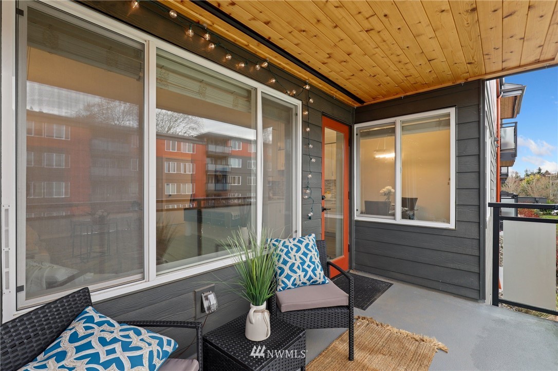 7001 Sand Point Way Northeast, Unit C309 Seattle, WA 98115 - Photo 20 of 38 a porch with a bench and glass door
