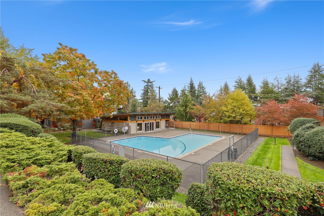 7001 Sand Point Way Northeast, Unit C309 Seattle, WA 98115 - Photo 26 of 38 a view of a swimming pool with an outdoor seating and a garden