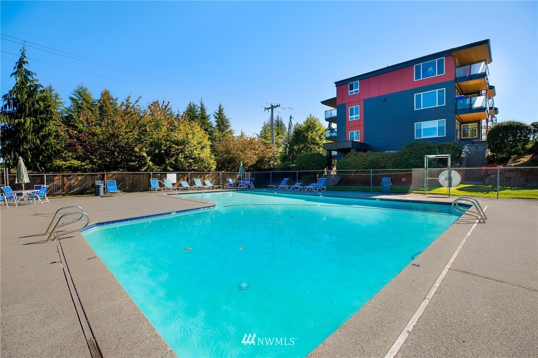 7001 Sand Point Way Northeast, Unit C309 Seattle, WA 98115 - Photo 27 of 38 a view of a swimming pool with a yard and sitting area