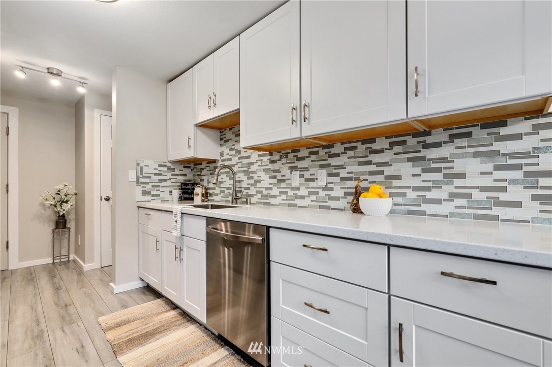 7001 Sand Point Way Northeast, Unit C309 Seattle, WA 98115 - Photo 6 of 38 a kitchen with stainless steel appliances granite countertop a sink and cabinets