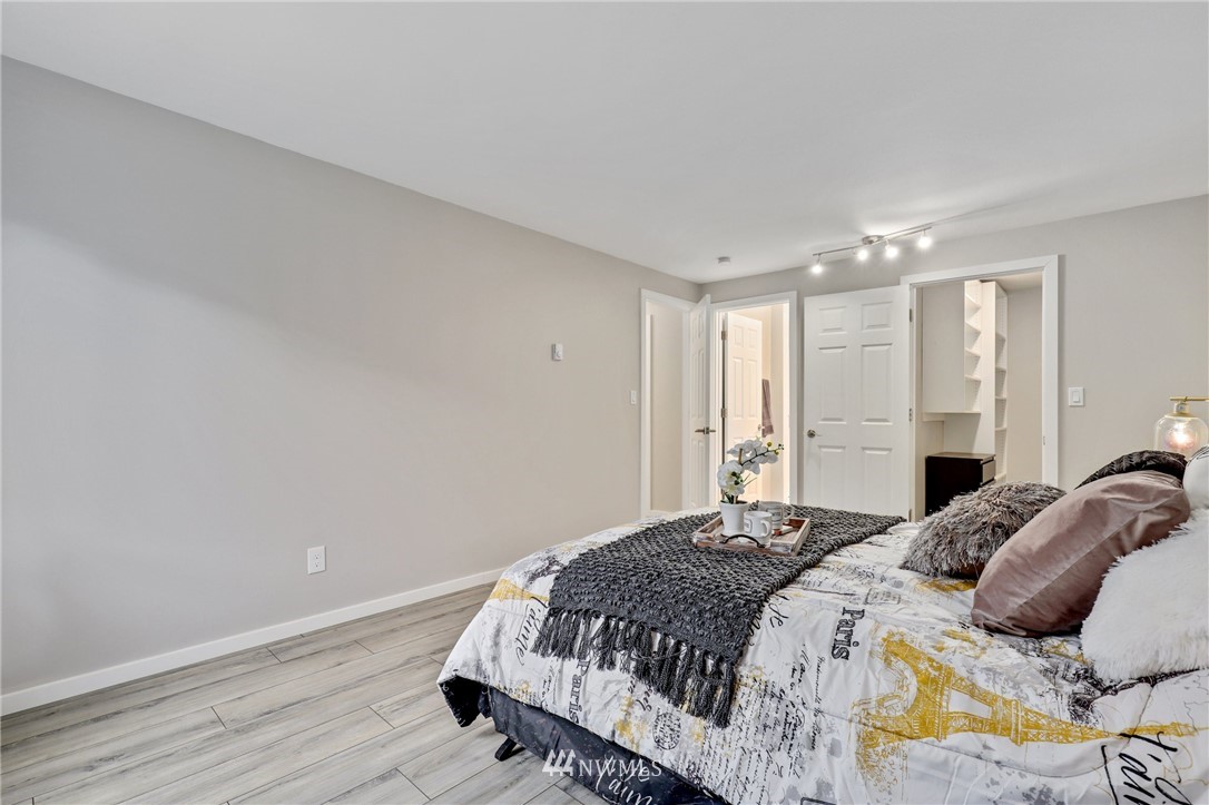 7001 Sand Point Way Northeast, Unit C309 Seattle, WA 98115 - Photo 10 of 38 a bedroom with a bed and wooden floor