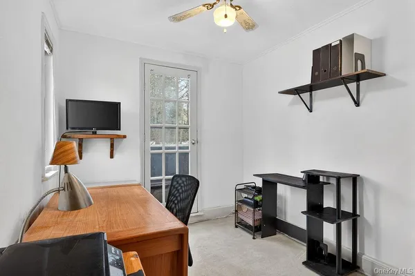 a view of a workspace with furniture and a window