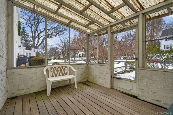 a view of a porch with wooden floor and furniture