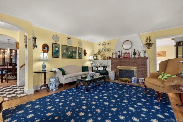 a living room with furniture a fireplace and wooden floor