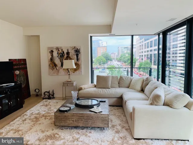 a living room with furniture large window and a flat screen tv