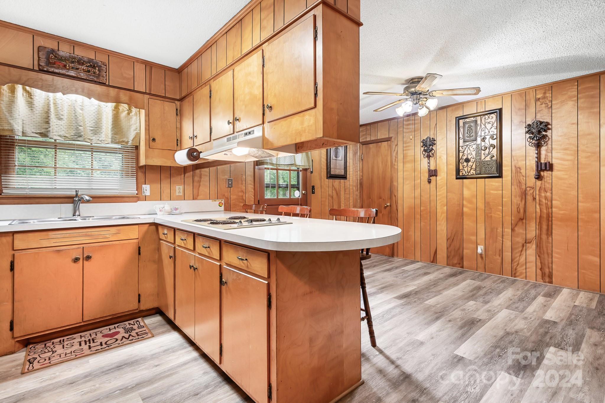 918 Blacksnake Road Stanley, NC 28164 - Photo 8 of 41 a kitchen with stainless steel appliances granite countertop a sink a microwave cabinets and wooden floor