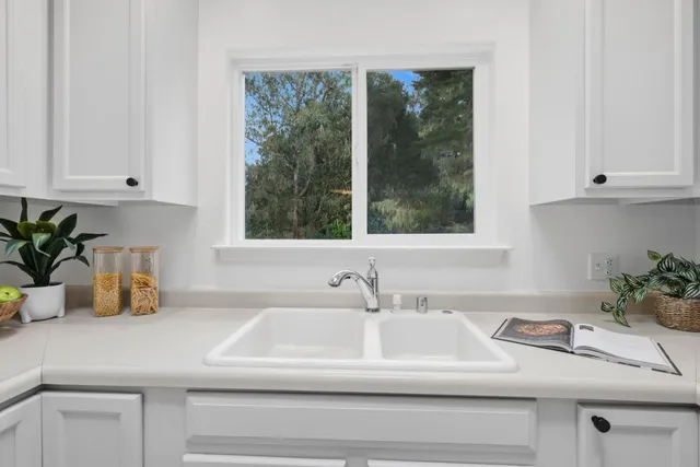 a bathroom with a sink a mirror and next to a window
