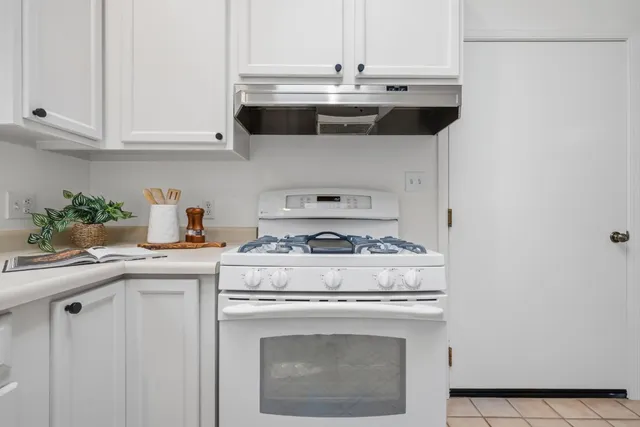 a stove top oven sitting inside of a kitchen