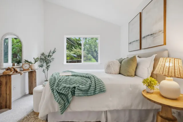 a living room with a bed furniture and a potted plant