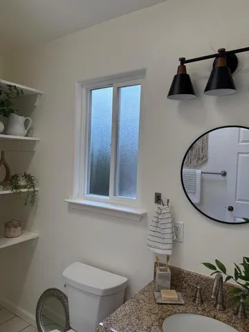 a bathroom with a toilet a sink and mirror