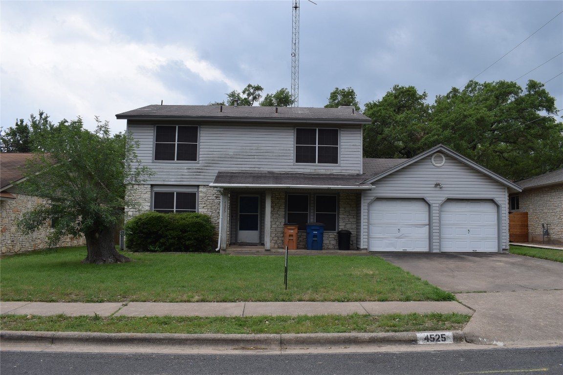 a front view of a house with a garden and yard