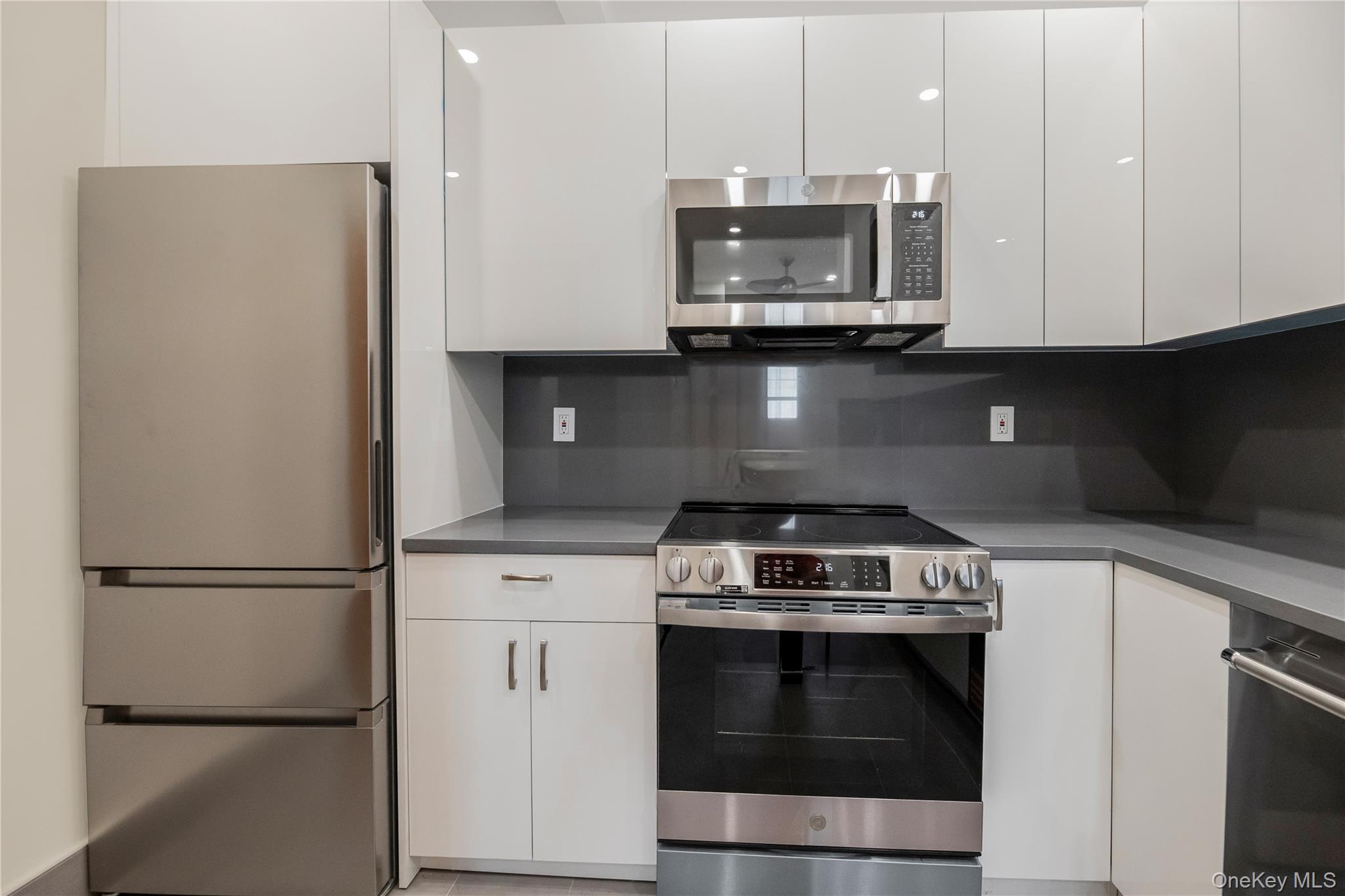 26 Pondfield Road, Unit 1D Bronxville, NY 10708 - Photo 6 of 21 a kitchen with stainless steel appliances granite countertop a stove a refrigerator and a microwave