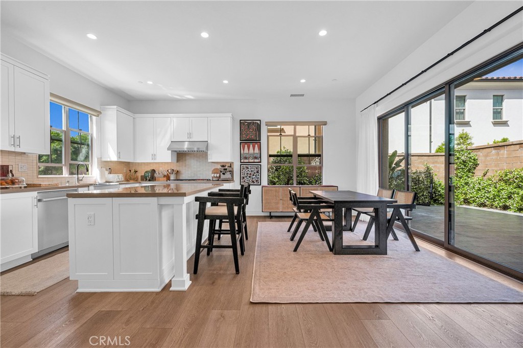 115 Halworth Irvine, CA 92618 - Photo 12 of 33 a open dining room with kitchen island granite countertop wooden floor a dining table and chairs