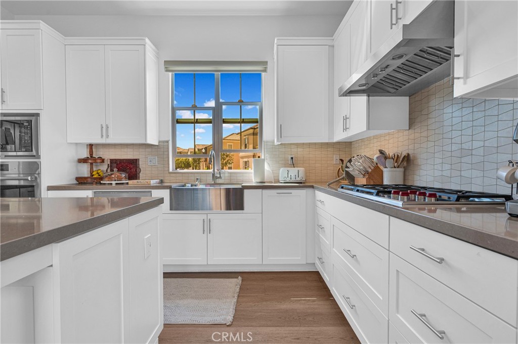 115 Halworth Irvine, CA 92618 - Photo 6 of 33 a kitchen with white cabinets and appliances