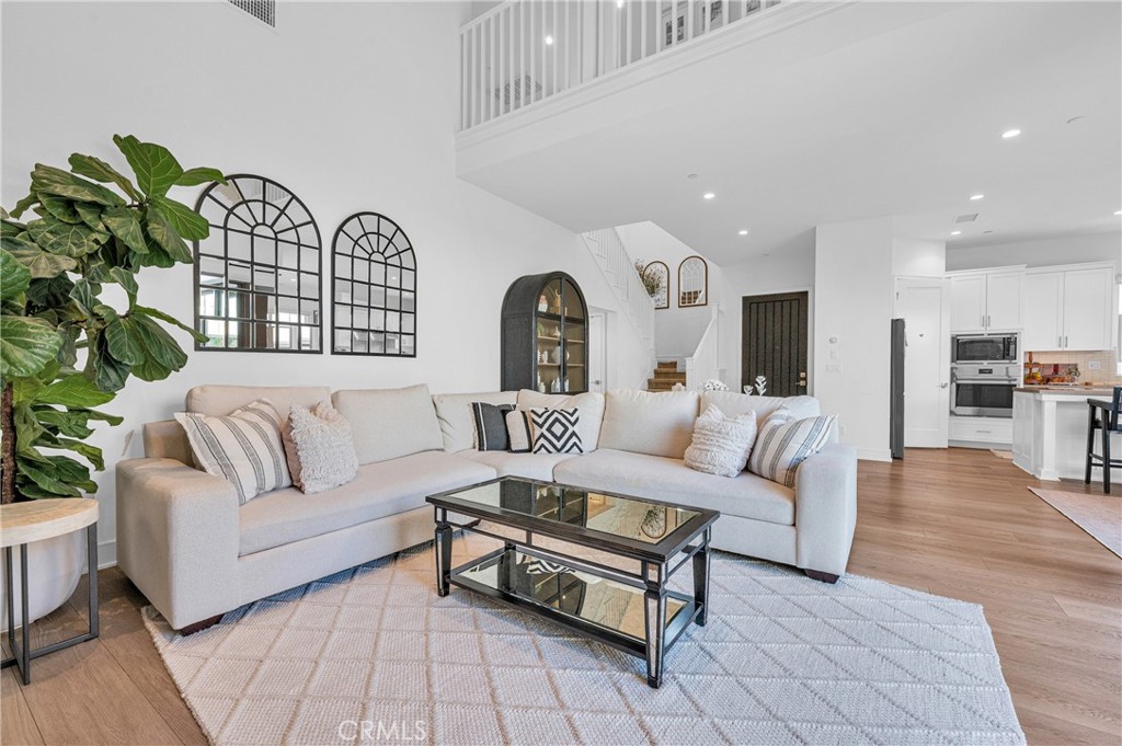 115 Halworth Irvine, CA 92618 - Photo 9 of 33 a living room with furniture a wooden floor and a potted plant