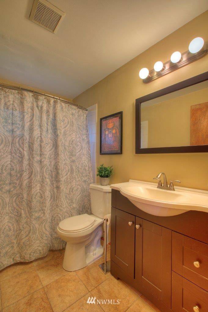 4209 Northeast 11th Street Renton, WA 98059 - Photo 9 of 17 a bathroom with a granite countertop toilet sink and mirror