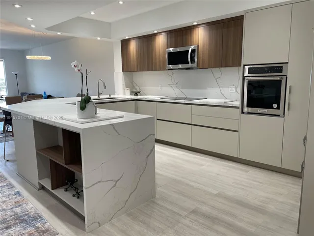 a kitchen with kitchen island a sink stainless steel appliances and cabinets