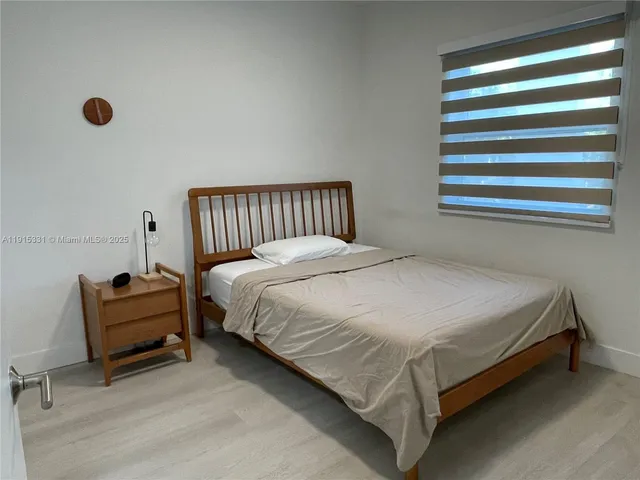 a bed sitting in a bedroom next to a window