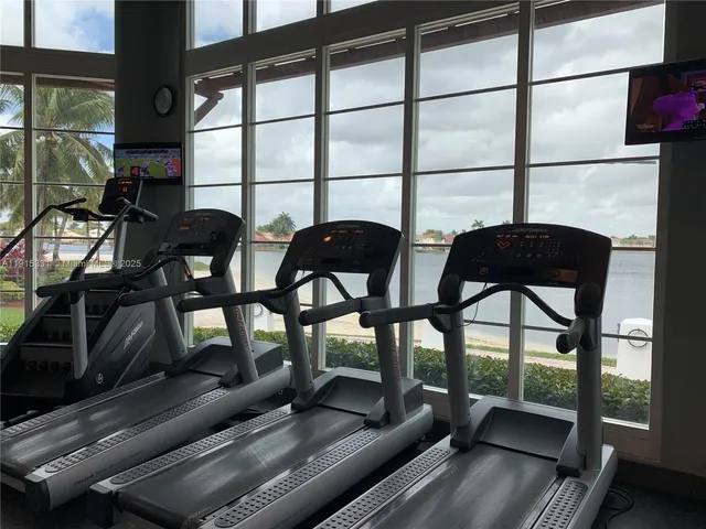 a view of a living room and balcony with furniture and wooden floor
