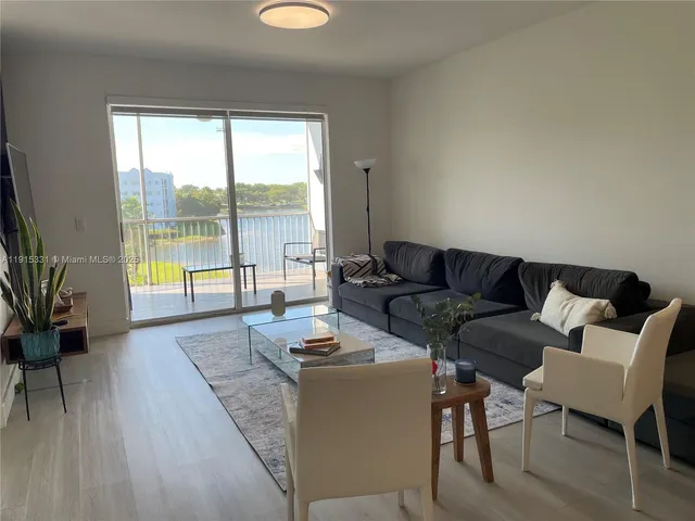 a living room with furniture and a floor to ceiling window
