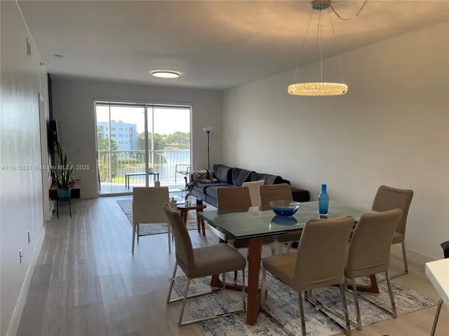 a dining room with furniture and a floor to ceiling window