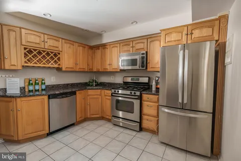 a kitchen with stainless steel appliances granite countertop a refrigerator sink and stove
