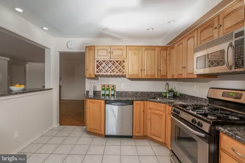 a kitchen with stainless steel appliances granite countertop a stove a sink and a granite counter tops