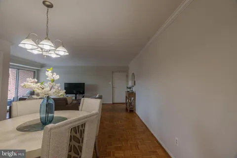 a dining room with furniture a chandelier and wooden floor