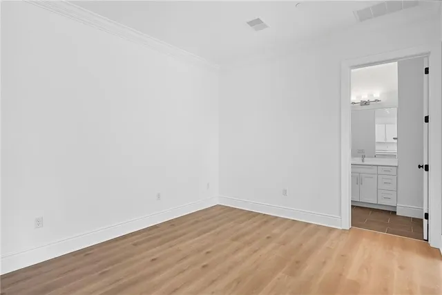 a view of an empty room with wooden floor and closet