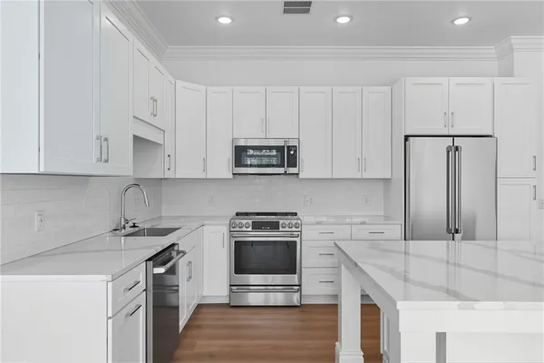 a kitchen with granite countertop a sink stove and cabinets