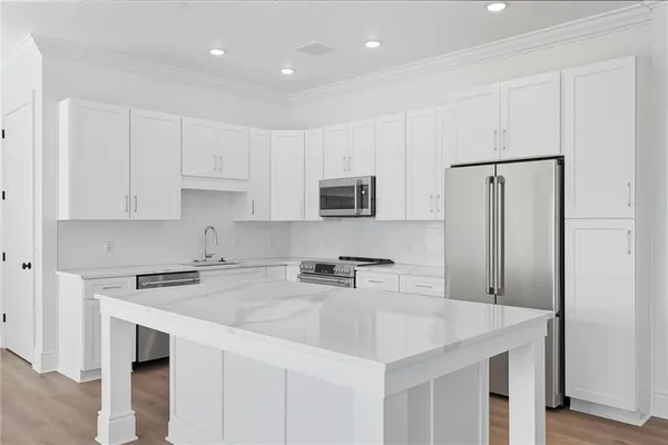a kitchen with stainless steel appliances a sink a stove a microwave and cabinets