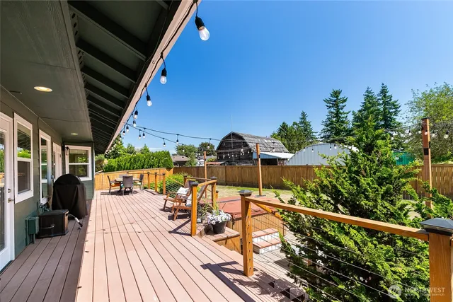 a view of a patio with table and chairs with wooden floor and fence