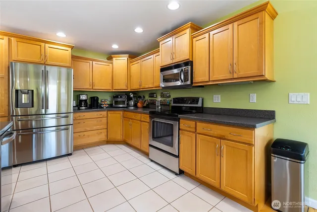 a kitchen with stainless steel appliances granite countertop a refrigerator and cabinets