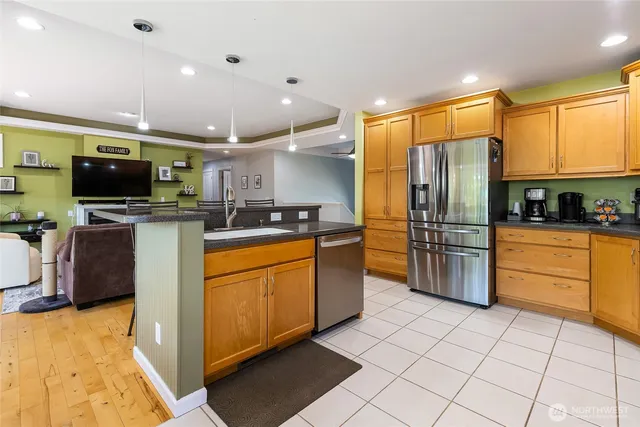 a kitchen with stainless steel appliances a refrigerator sink and microwave