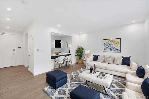 a living room with furniture potted plant and wooden floor