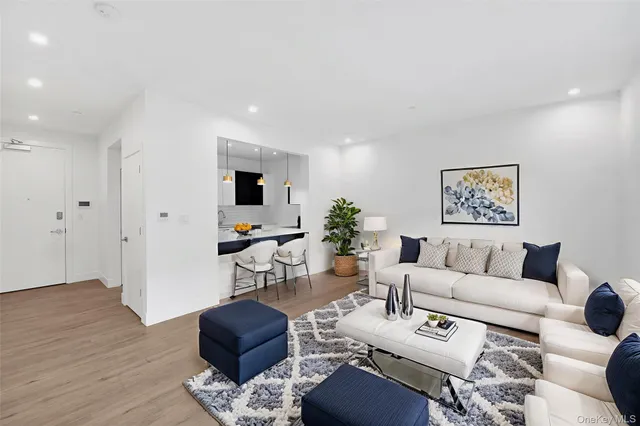 a living room with furniture potted plant and wooden floor