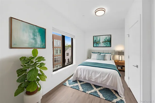 a bedroom with a bed potted plant and a window