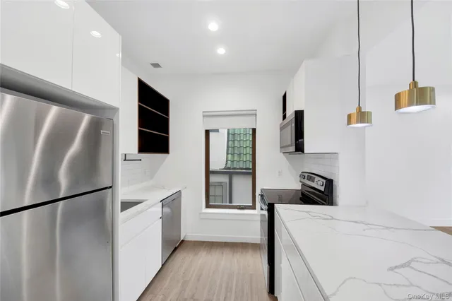 a kitchen with stainless steel appliances a refrigerator sink and microwave