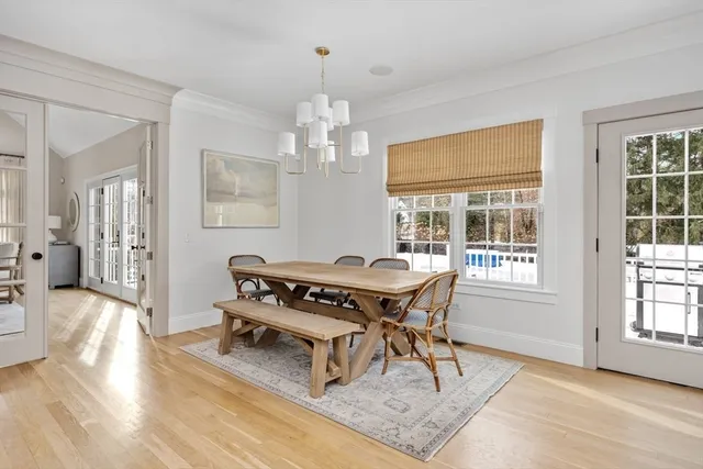 a dining room with wooden floor and a chandelier