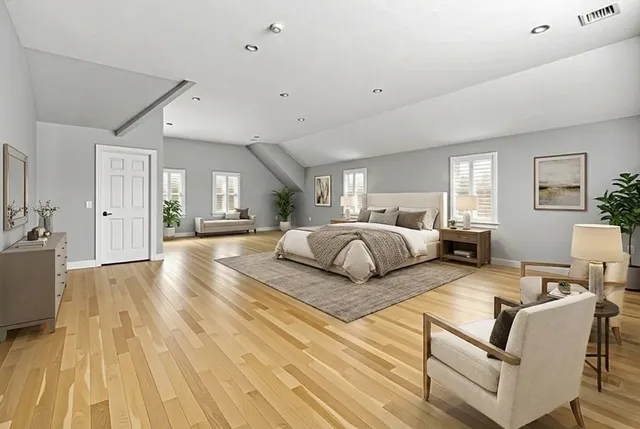 a bedroom with a large bed couch and a view of kitchen