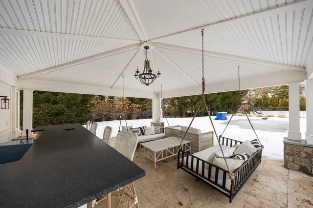 a view of a patio with couches chairs under an umbrella