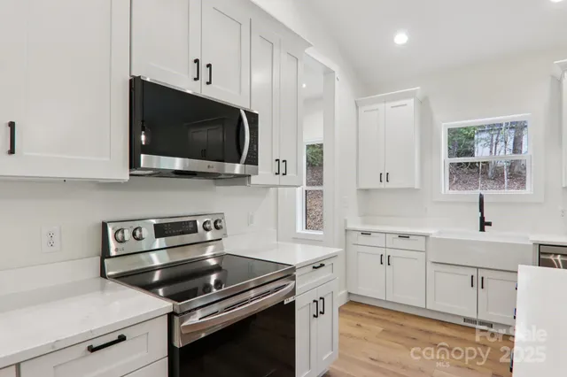 a kitchen with stainless steel appliances a stove a microwave and cabinets